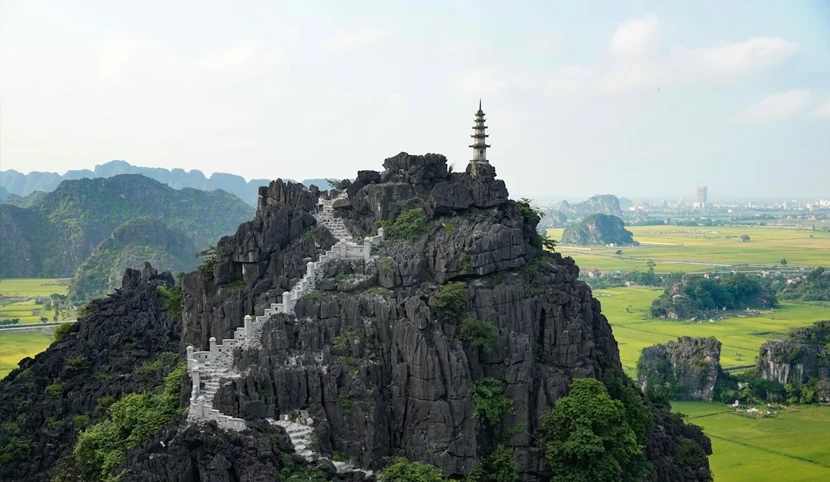 Ninh Binh brown and white pagoda on top of brown mountain