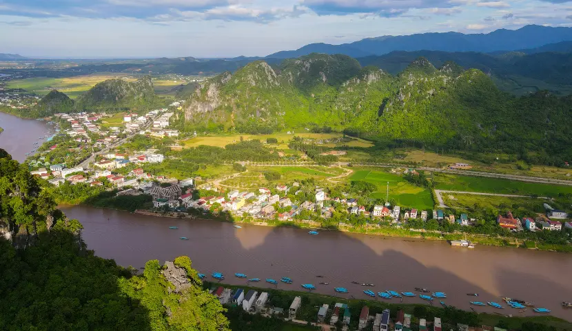 River flows through a lush green valley with mountains