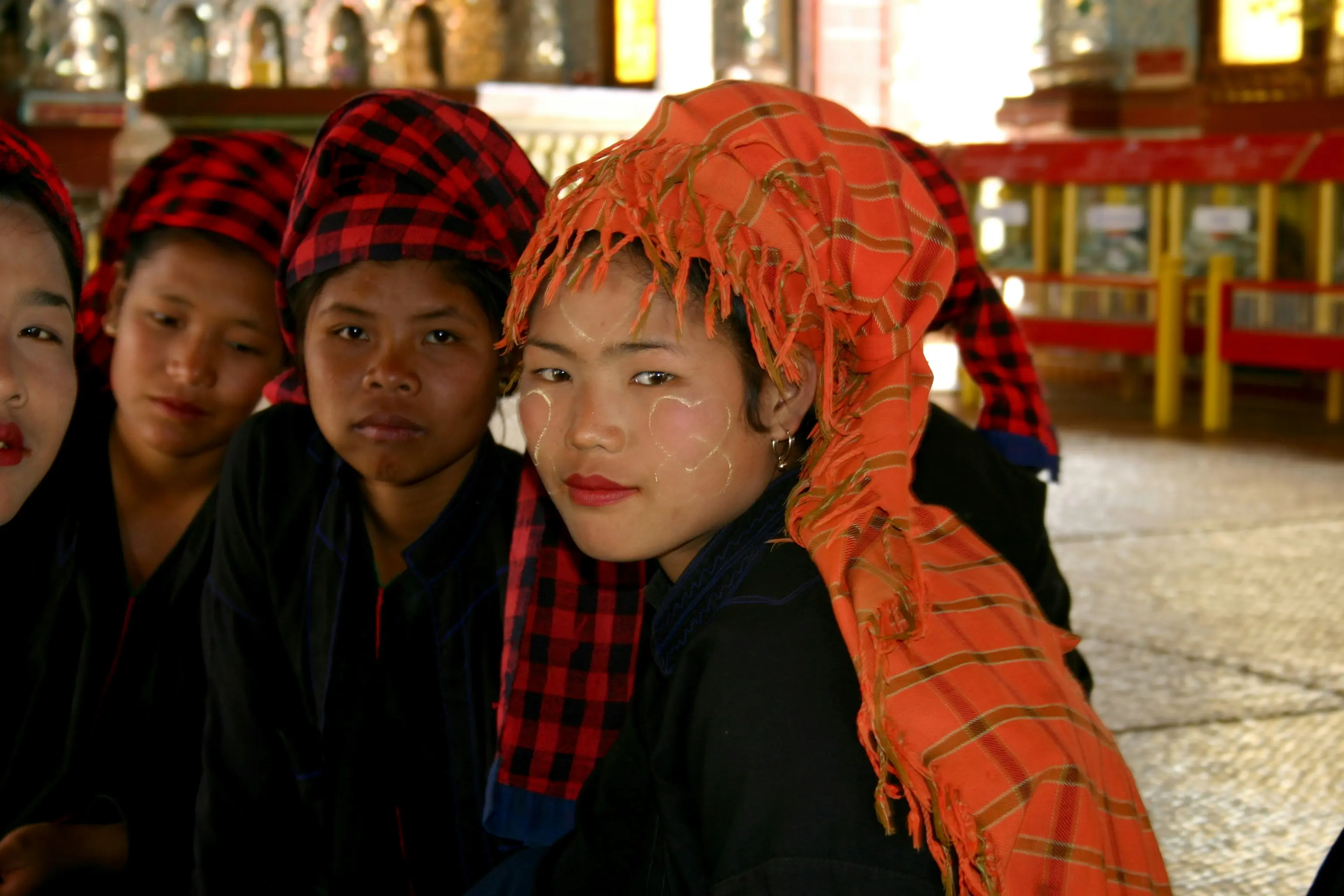 Woman in black jacket beside woman in orange scarf